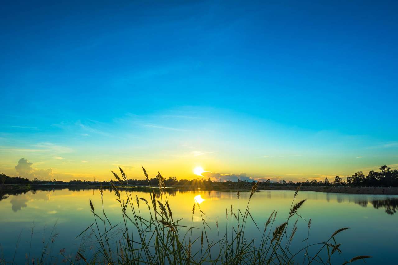 Sunset peisaj cu cer albastru la Lacul calm puzzle online