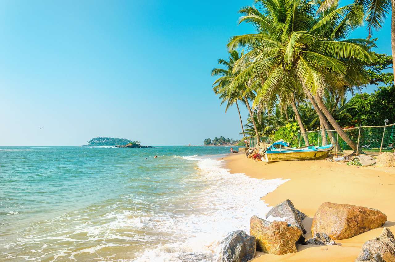 Vacker exotisk strand full av palmer mot det azurblå havet och blå himmel Pussel online