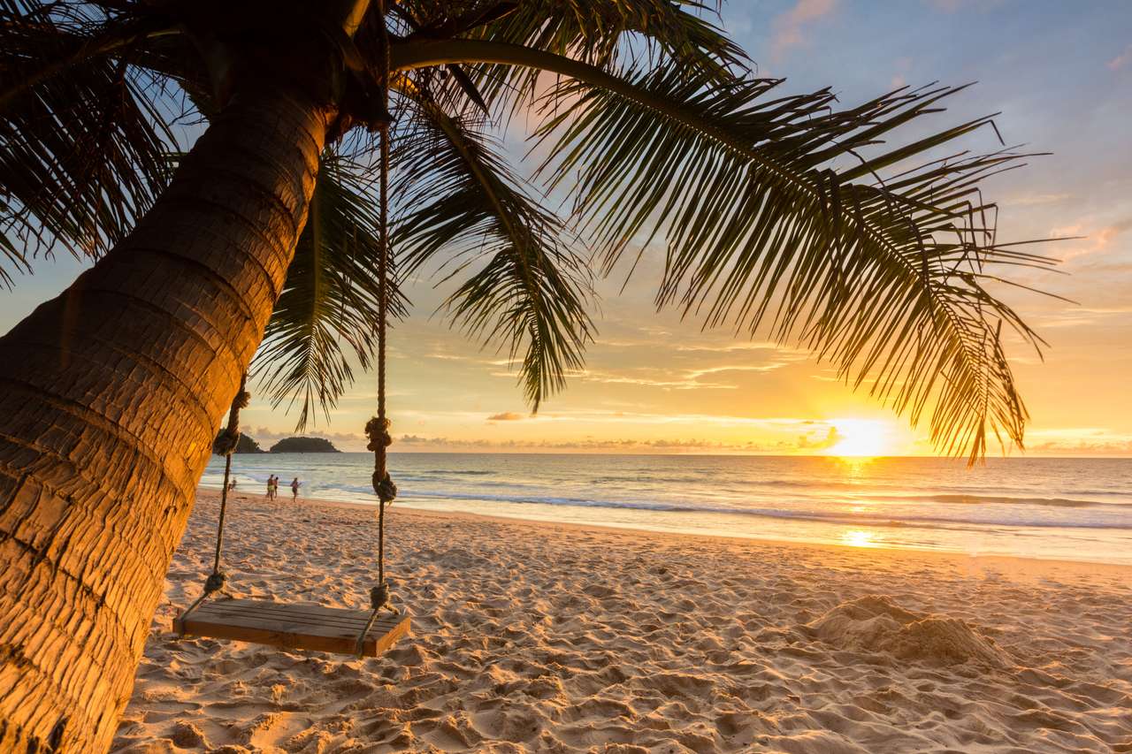 Leagăn din lemn sub cocos copac pe plajă cu fundal apus de soare jigsaw puzzle online