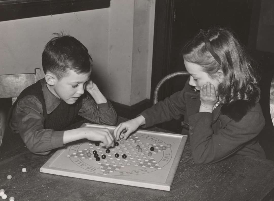 menina e menino jogando tabuleiro de xadrez puzzle online