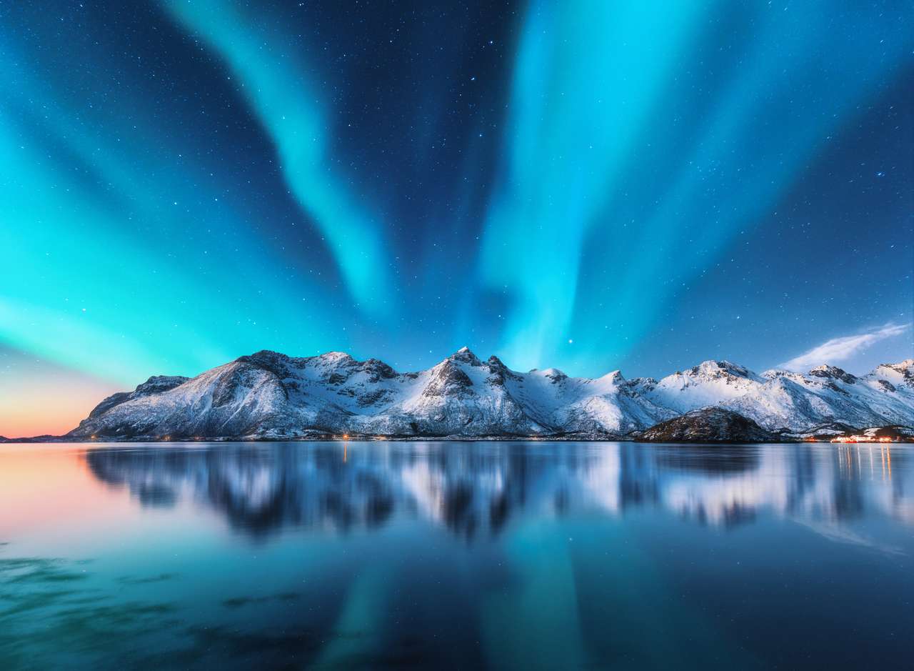 Északi fények és hófödte hegyek Lofoten-szigeteken, Norvégia. Aurora Borealis. Csillogó ég, poláris fényekkel és havas sziklákkal tükröződik a vízben. Éjszakai téli táj Aurora, tenger. Természet online puzzle