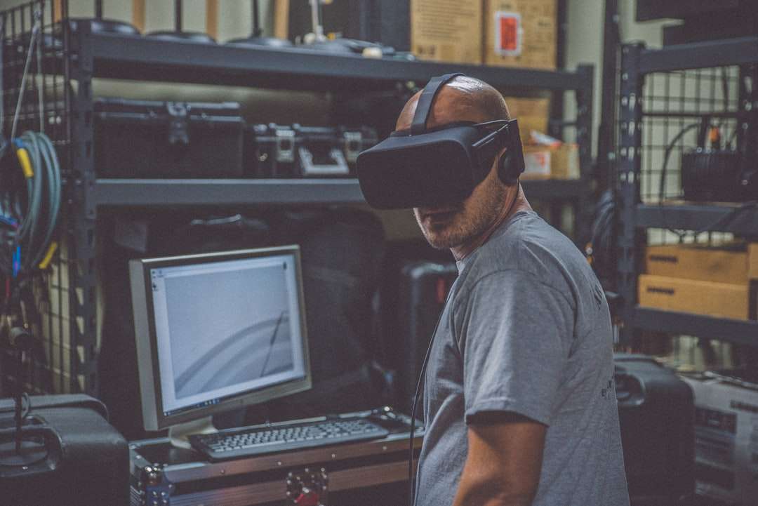 persona que usa auriculares VR negros frente a la computadora rompecabezas en línea