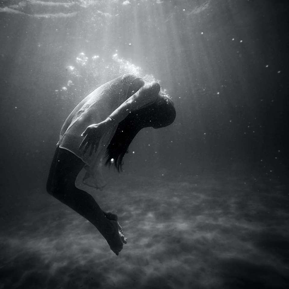 foto en escala de grises de una mujer ahogándose en el agua rompecabezas en línea