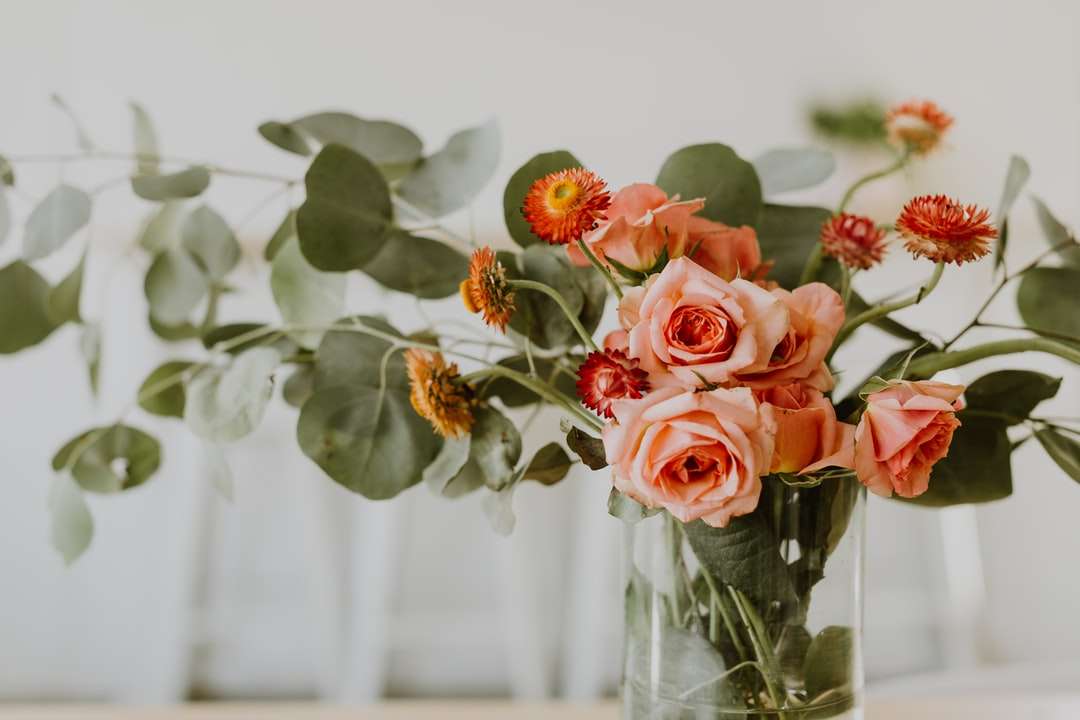 Затворете фотографията на розовите рози в ясна стъклена ваза онлайн пъзел