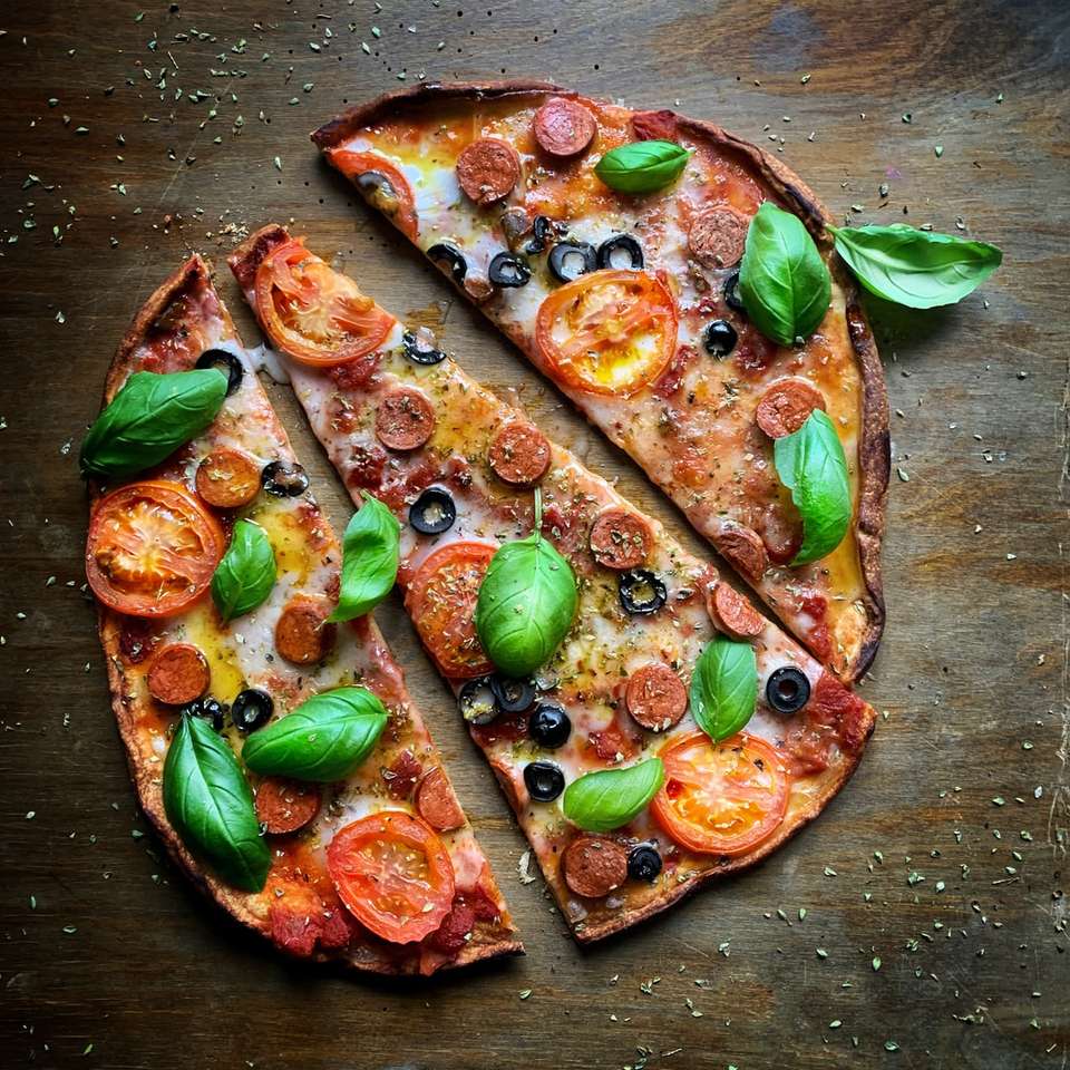 pizza with green leaves on brown wooden table jigsaw puzzle online