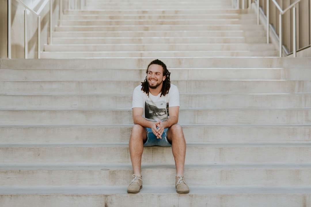 hombre sonriente sentado en la escalera rompecabezas en línea