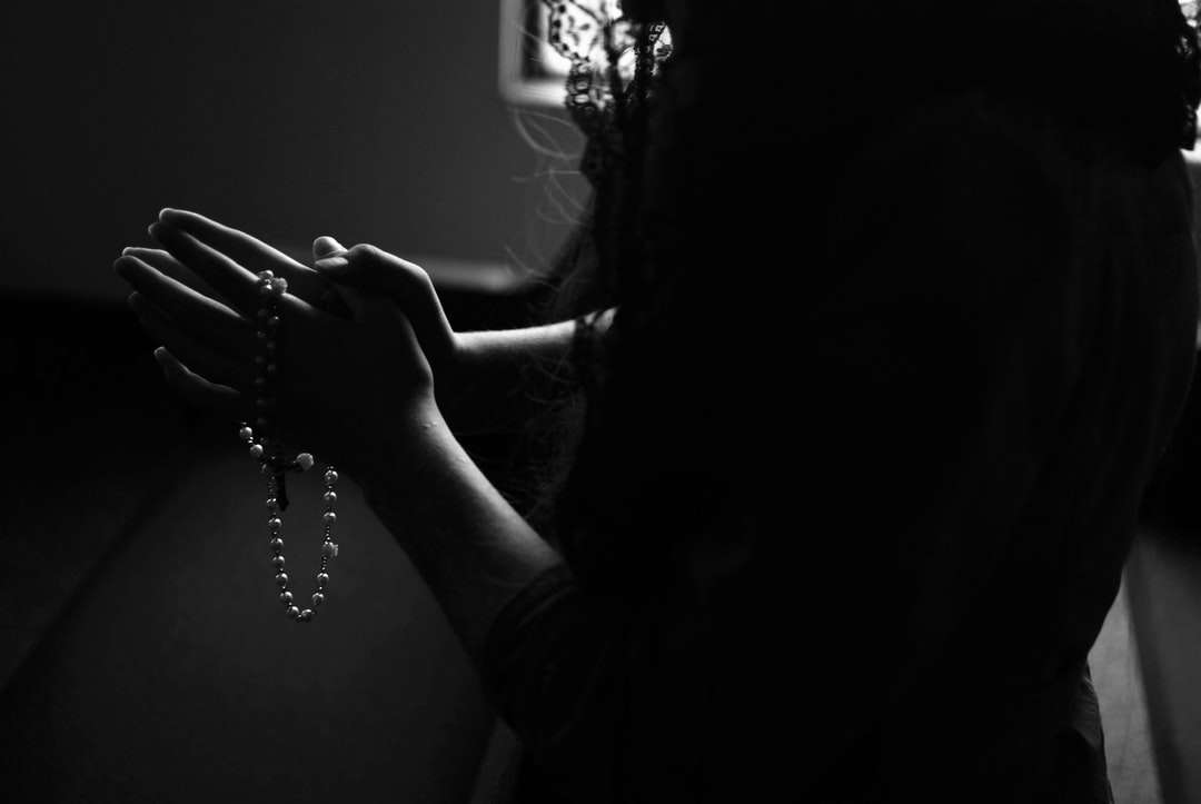 Silhouette einer Frau, die beim Beten einen Rosenkranz hält Online-Puzzle