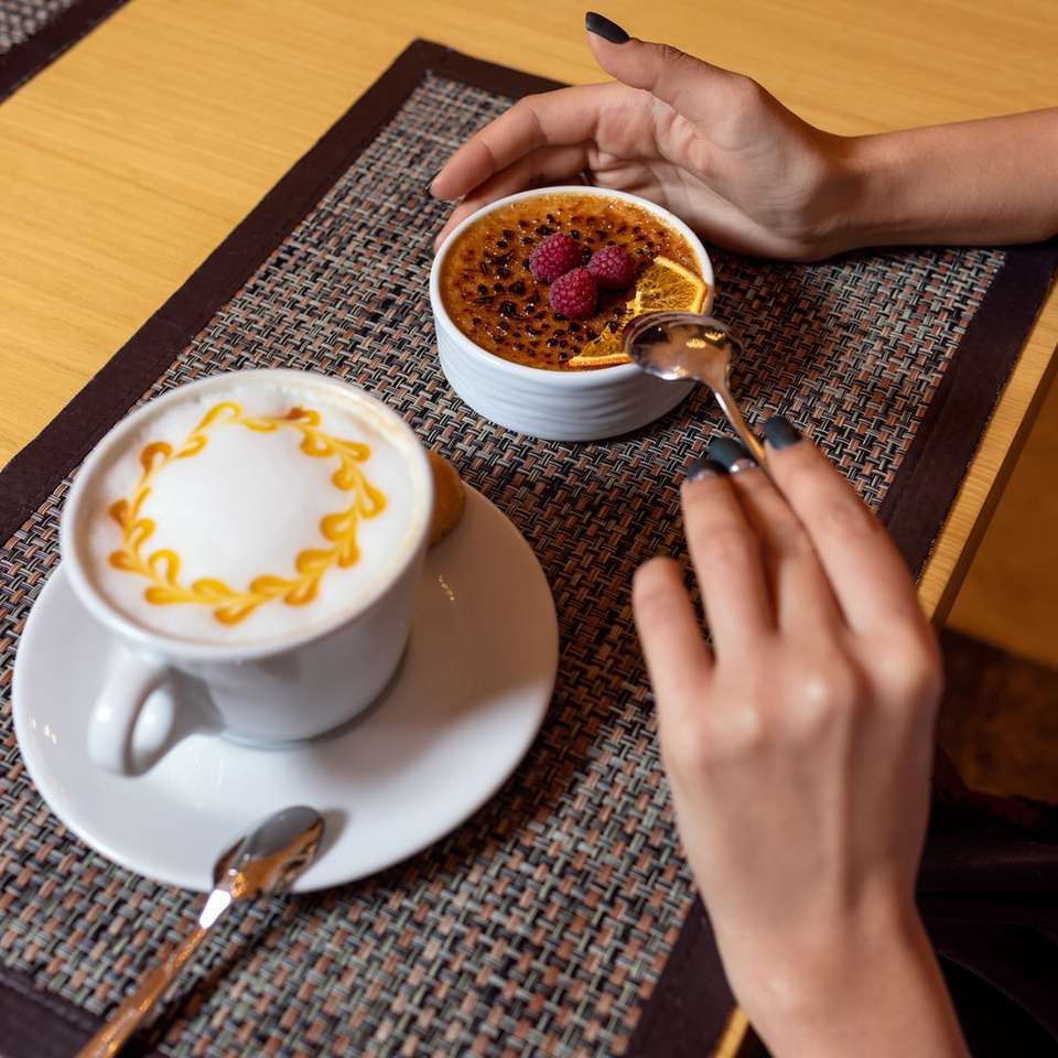 person holding white ceramic cup with saucer and spoon online puzzle