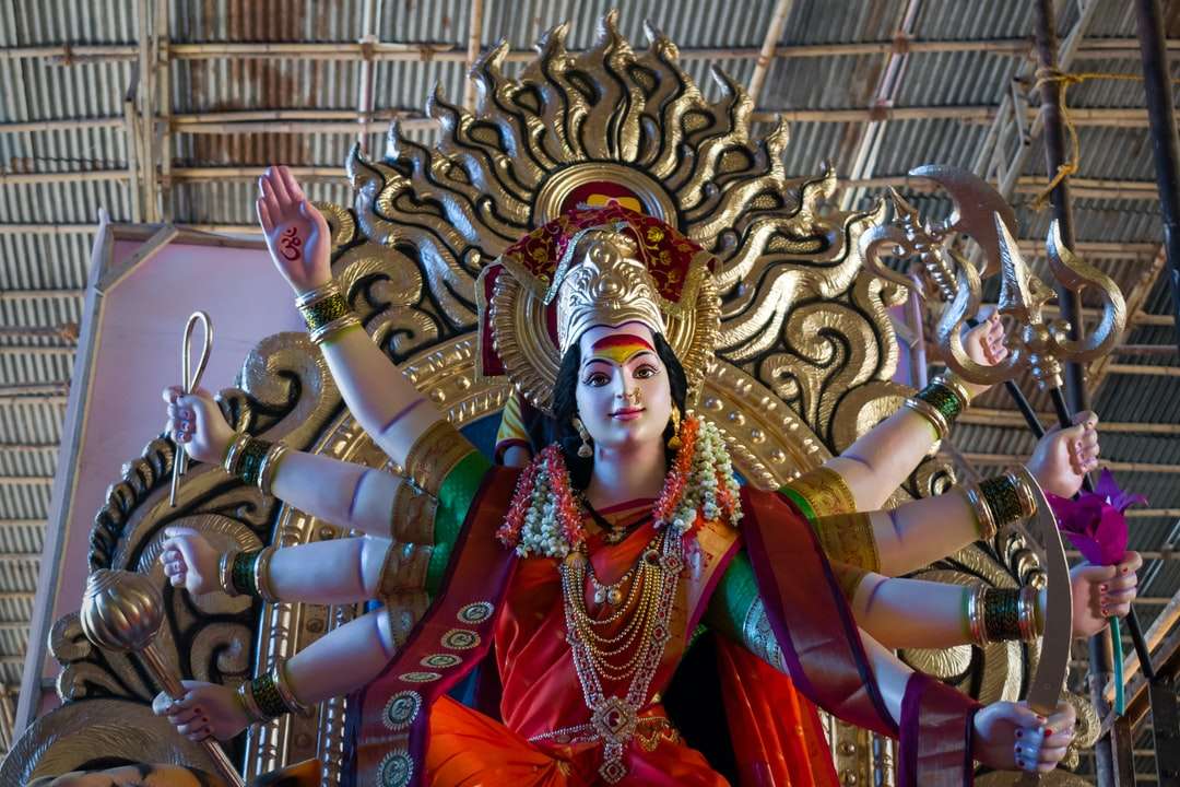 hinduistische Gottheitsstatue vor braunem Gebäude Online-Puzzle
