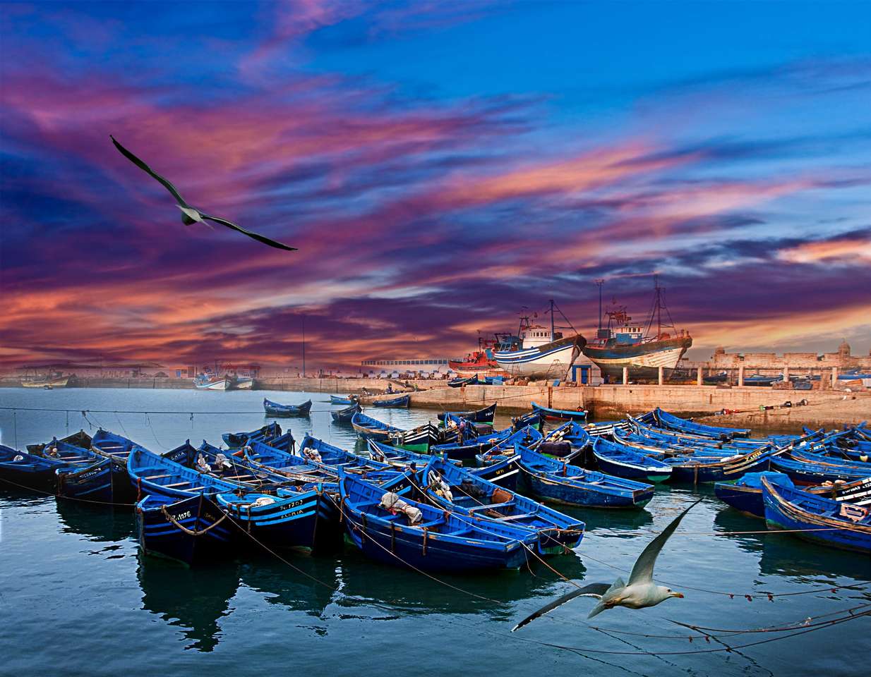 Blå fiskebåtar på en havskust i Essaouira, Marocko Pussel online