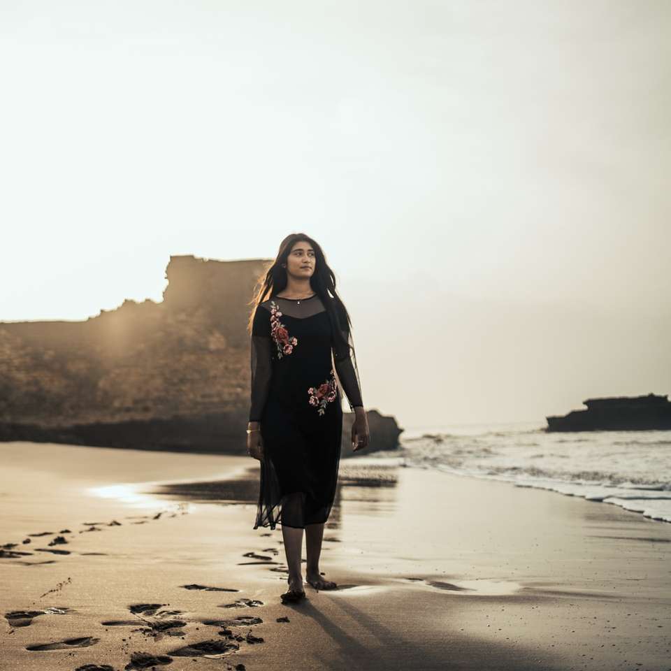 mulher em pé na costa durante o pôr do sol quebra-cabeças online