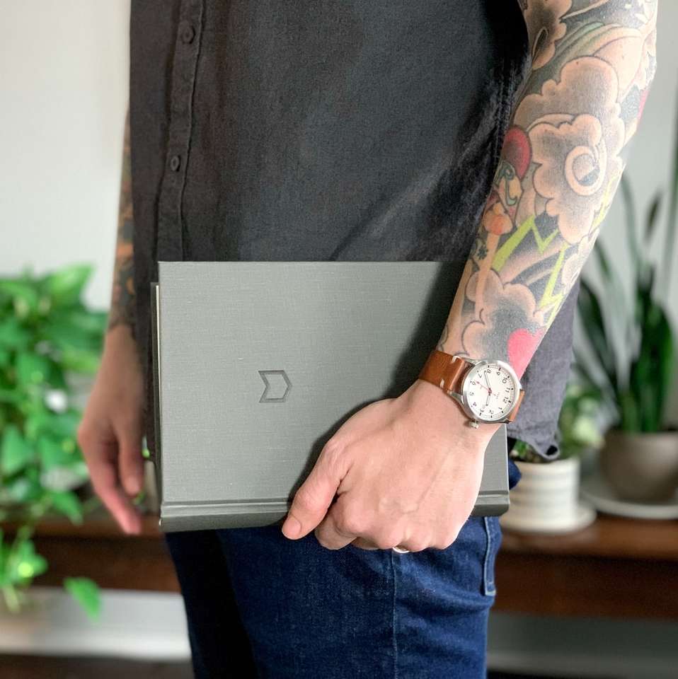 person im schwarzen hemd, das grauen laptop-computer hält Online-Puzzle