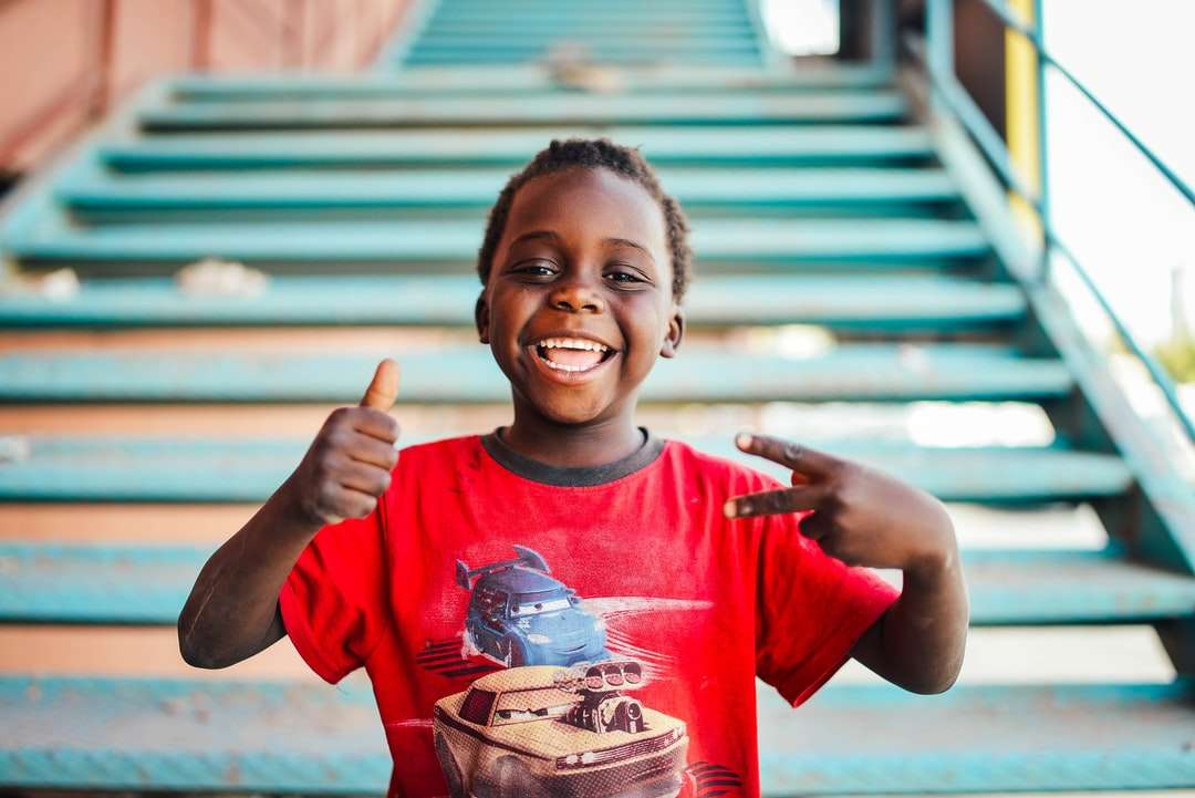 Junge, der in der Nähe von Treppen steht und tagsüber Friedenszeichen macht Online-Puzzle