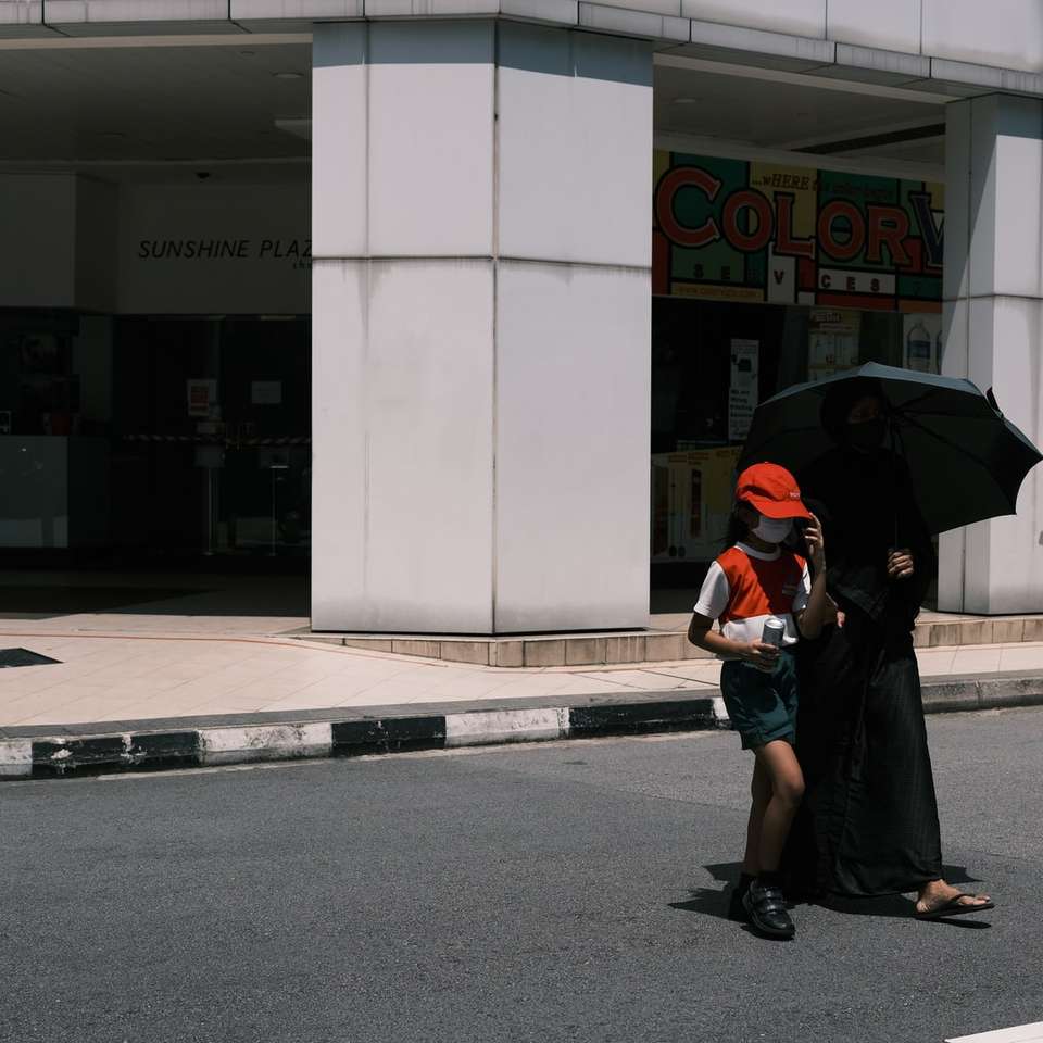 kvinna i svart jacka och svart kjol håller paraply Pussel online