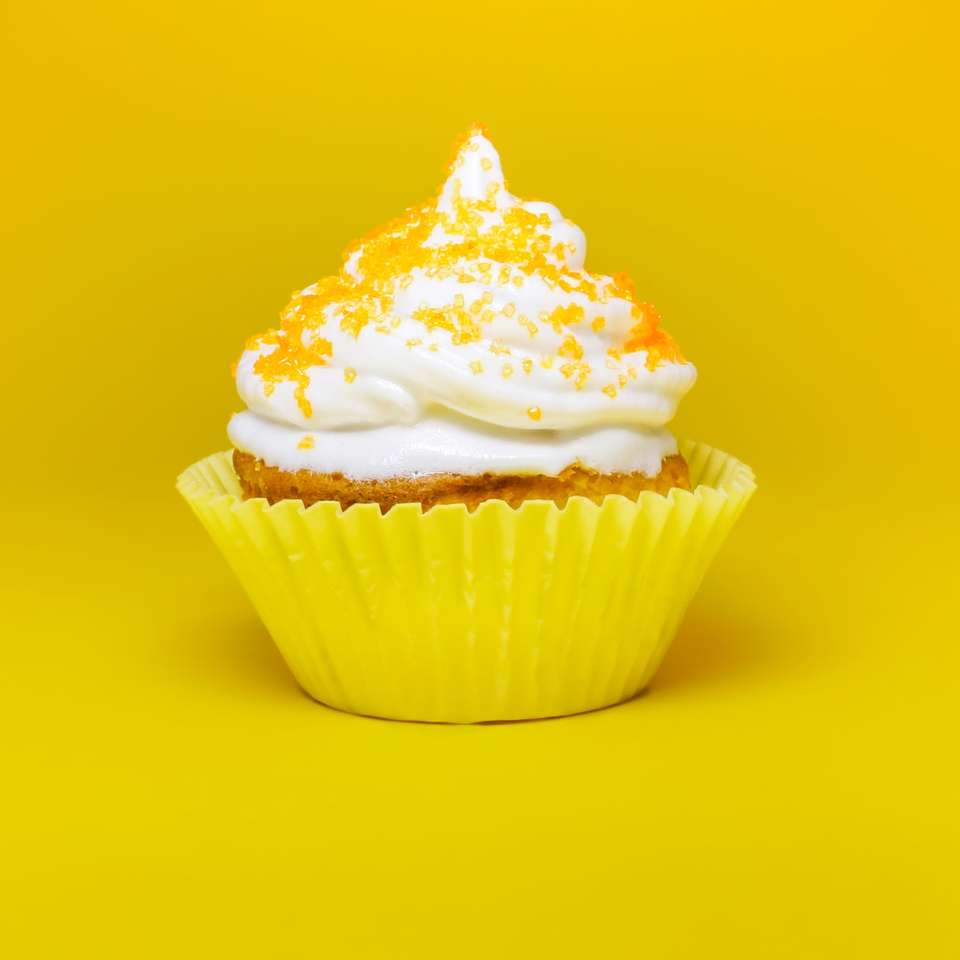 верх кекса з кремом у жовтій підставці для кексів онлайн пазл