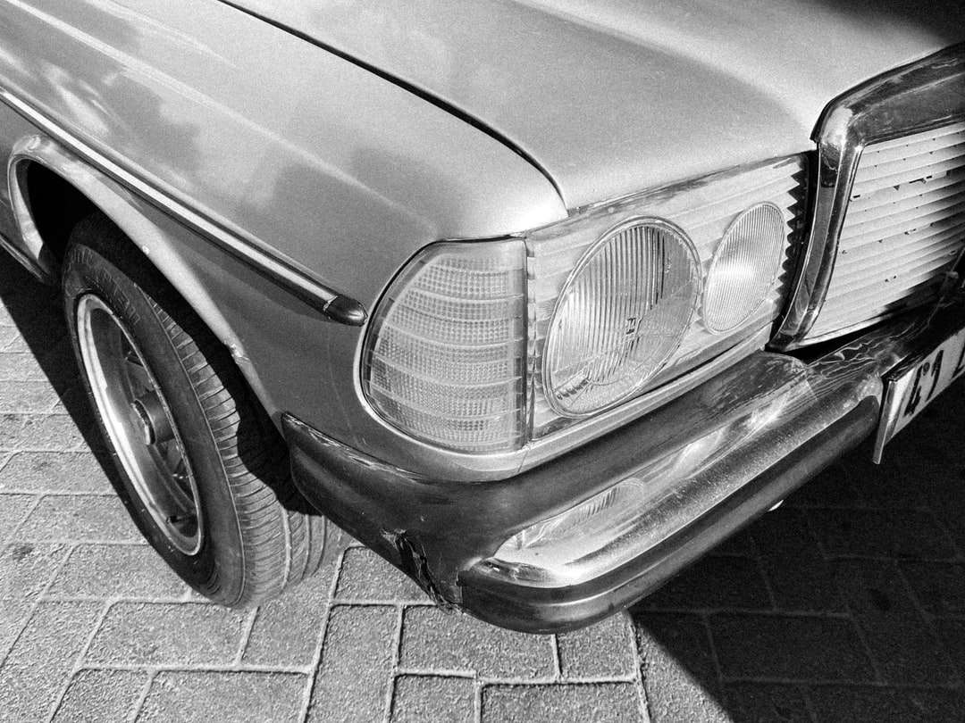 gråskalefoto av bil på tegelgolv Pussel online