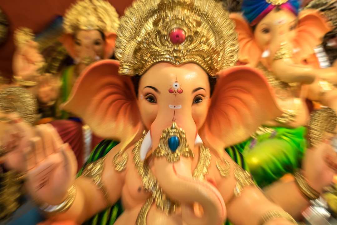 золота фігурка індуїстського божества на столі пазл онлайн