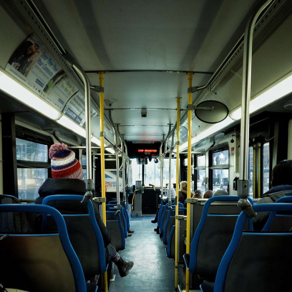 человек в черной куртке сидит на пассажирском кресле автобуса онлайн-пазл