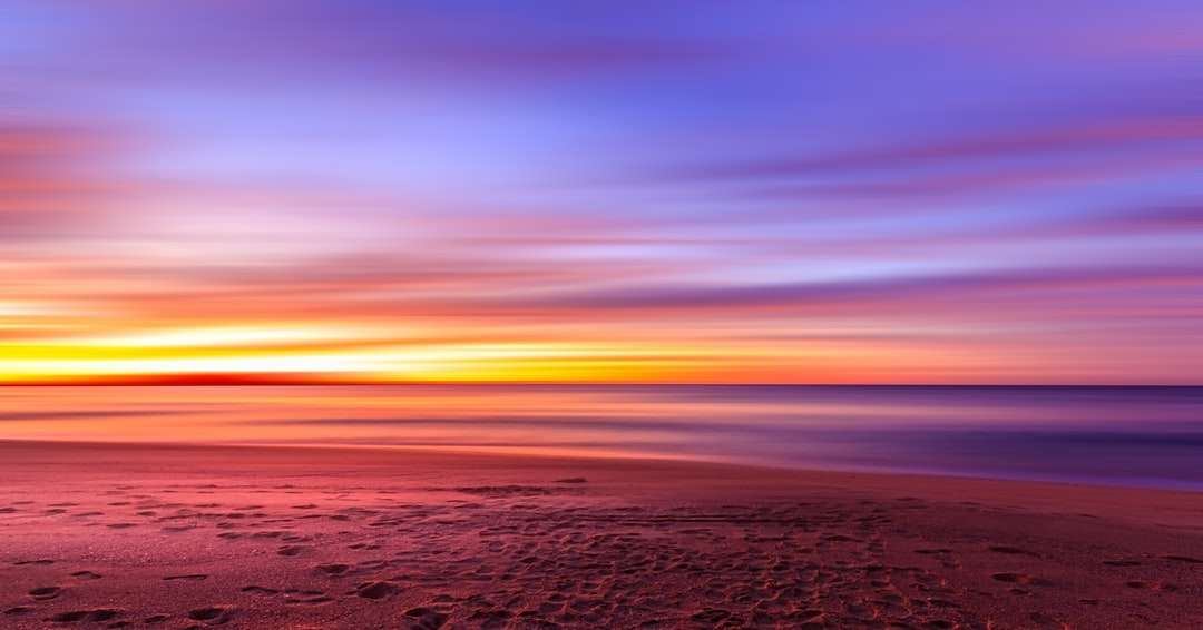вид на захід сонця на березі моря пазл онлайн