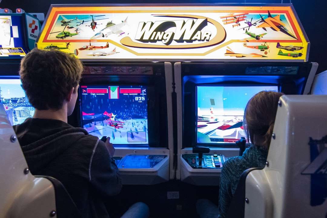 άνδρας με μαύρο σακάκι βλέποντας στο arcade παιχνίδι online παζλ