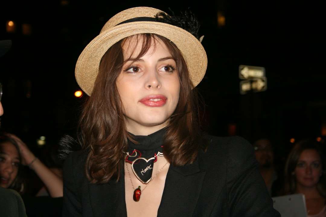 mujer con chaqueta negra y sombrero marrón rompecabezas en línea