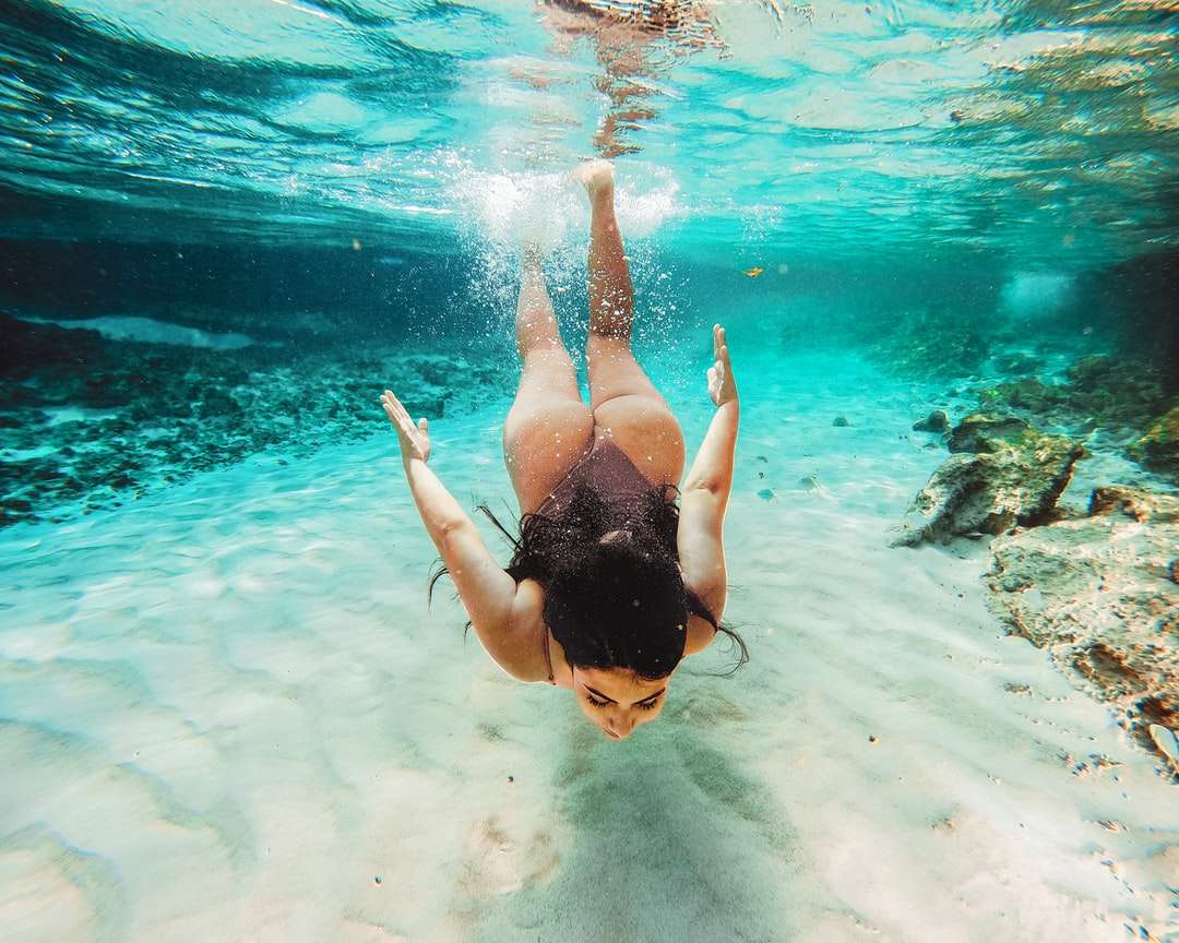水で泳いでいる黒いビキニの女性 ジグソーパズルオンライン