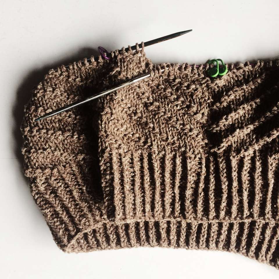 коричневый вязаный свитер на белом столе пазл онлайн