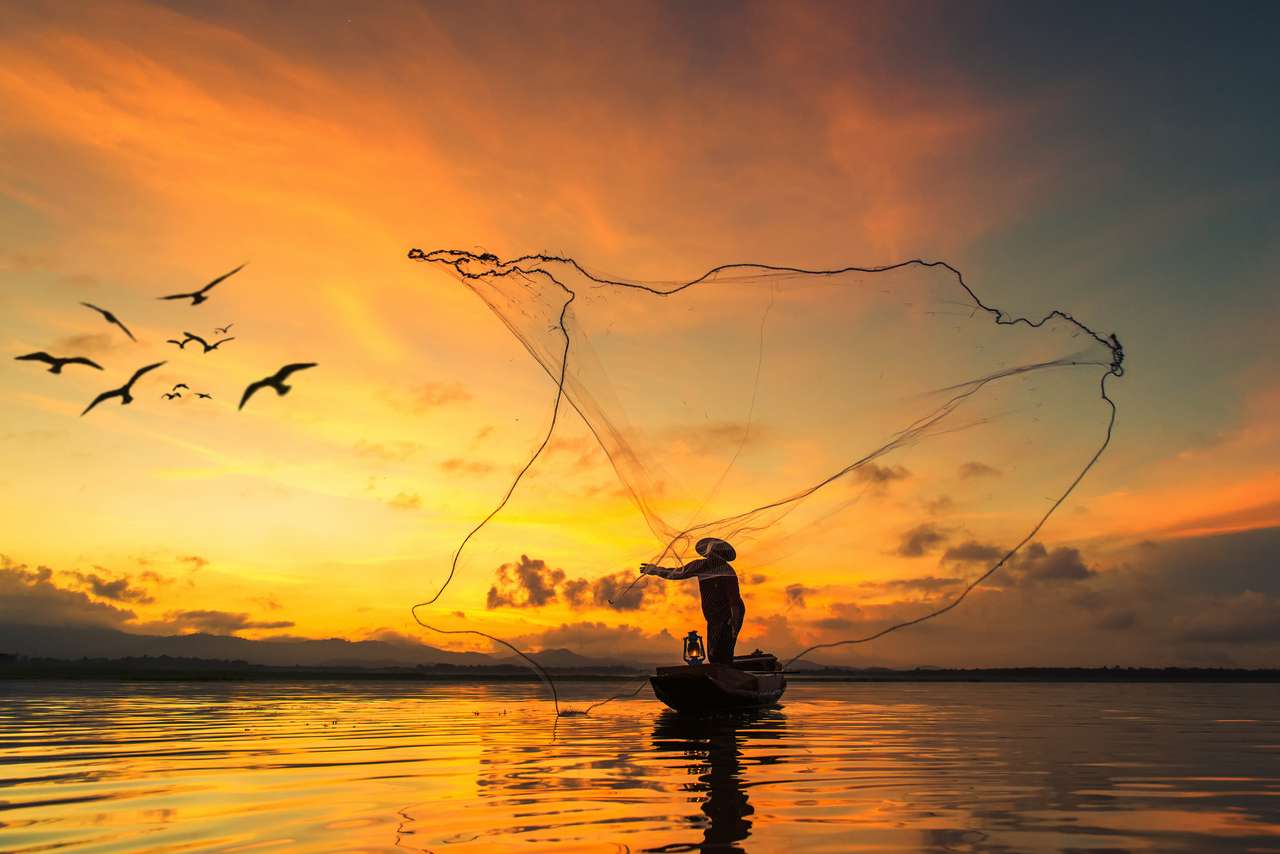 Рыбак ловит рыбу на озере утром, Таиланд. онлайн-пазл