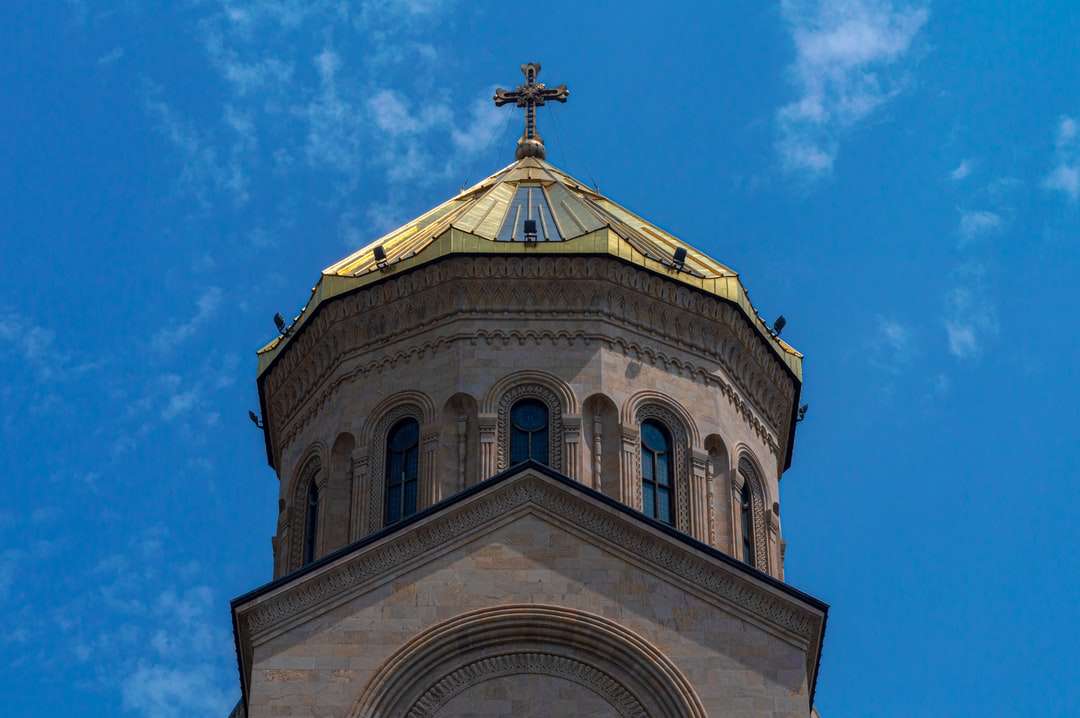 bílý a hnědý betonový kostel pod modrou oblohou online puzzle