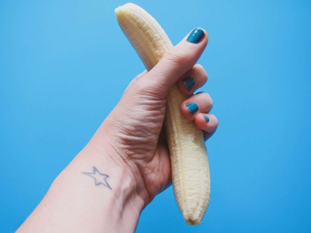 Person, die geschälte Bananenfrucht hält Online-Puzzle