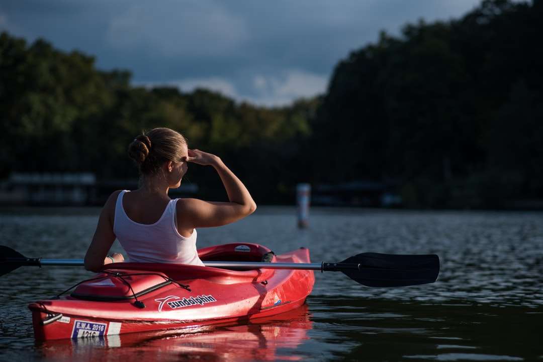 mujer mirando los árboles mientras monta en kayak rompecabezas en línea