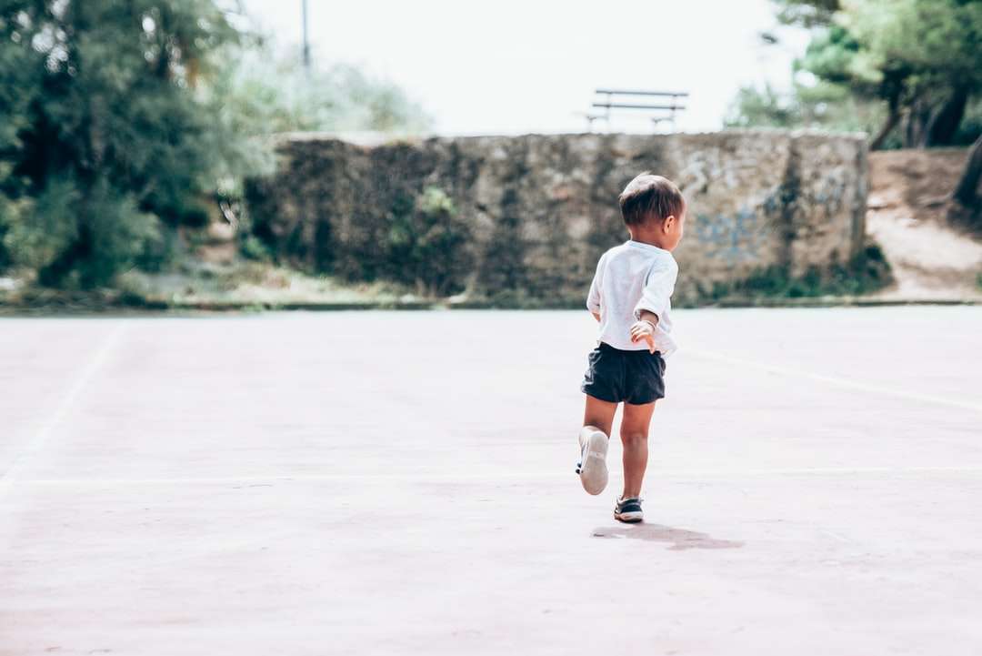 малыш бежит по серому бетонному полу онлайн-пазл