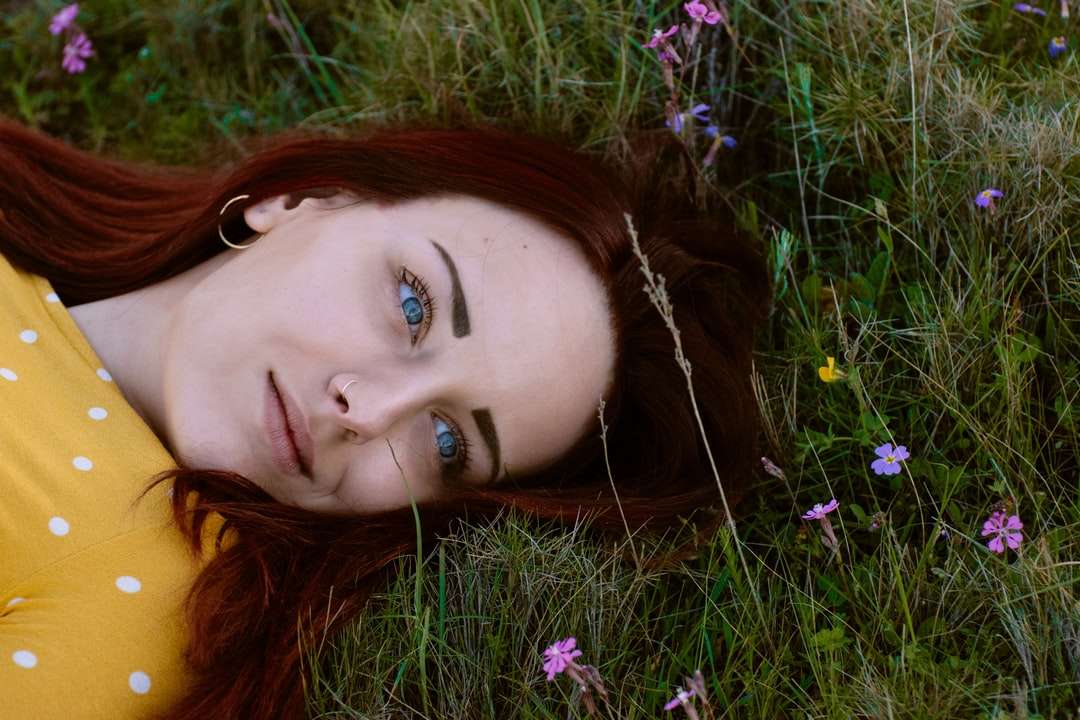 donna in marrone e bianco a pois top sdraiato nell'erba verde puzzle online