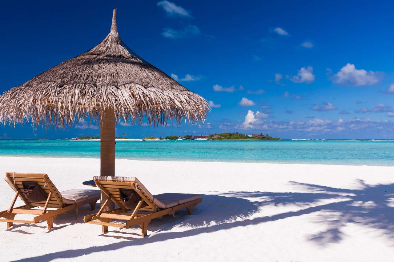 Två stolar och paraply på en strand pussel på nätet