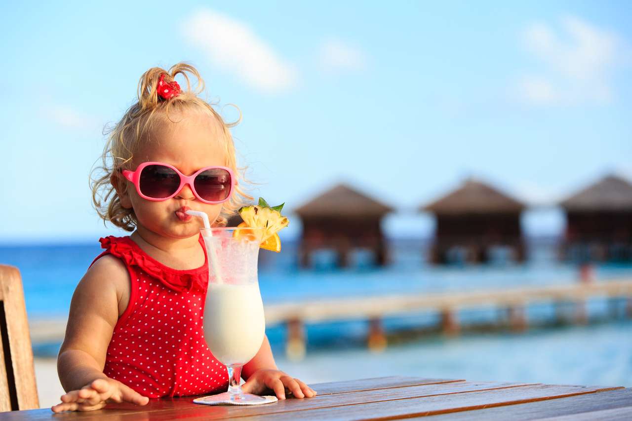Liten flicka som dricker cocktail på tropisk strand pussel på nätet