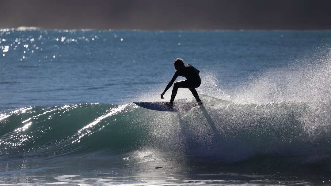 persoon die surfplank berijdt op waterton legpuzzel online