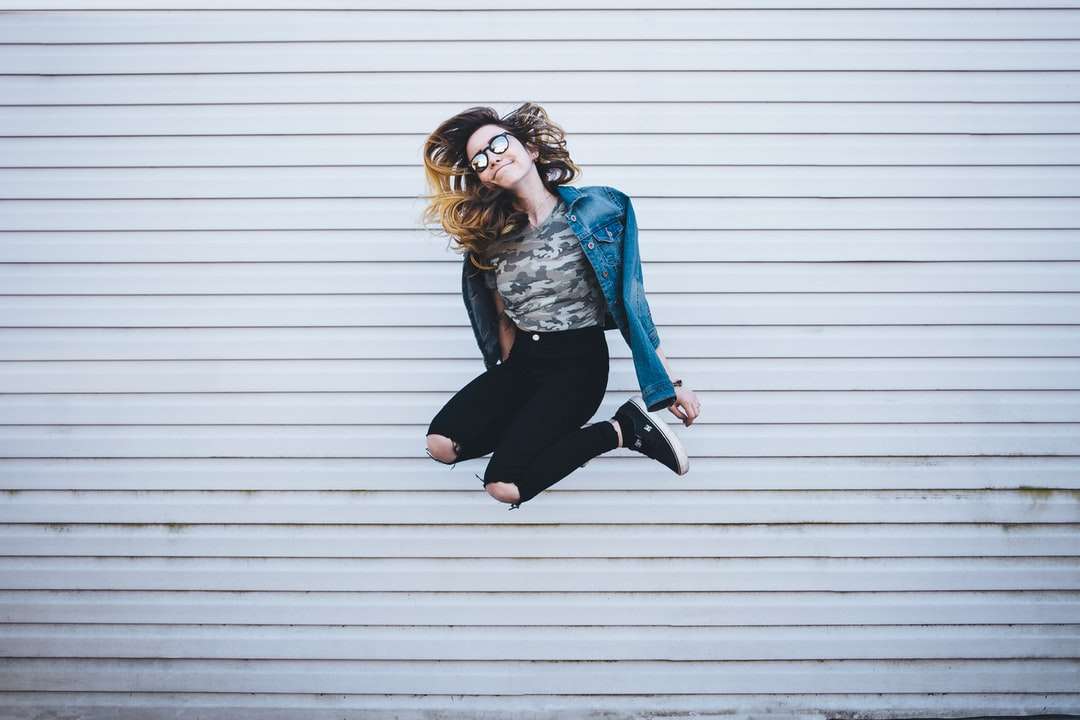 жінка стрибає перед білим бетонним закладом пазл онлайн