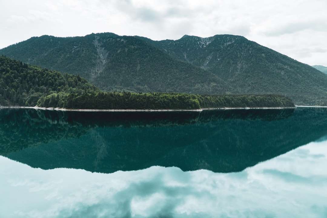 corpo calmo de água perto da montanha puzzle online
