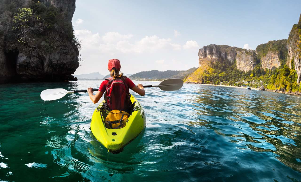 Signora che rema il kayak nella tranquilla baia tropicale puzzle online