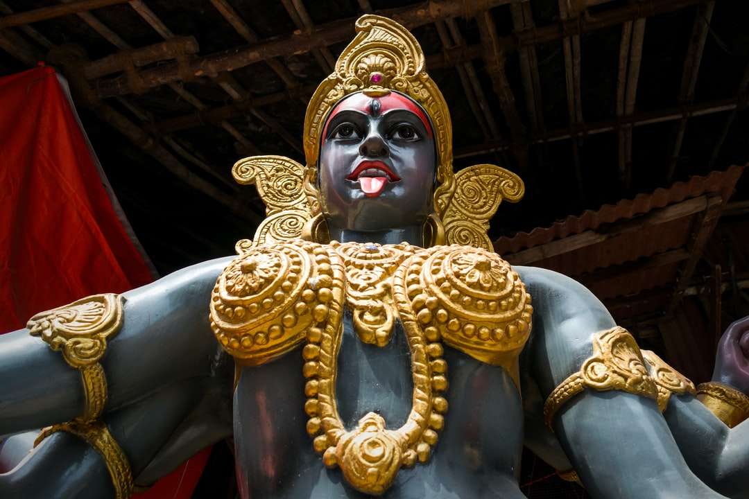 золота статуя індуїстського божества в кімнаті онлайн пазл