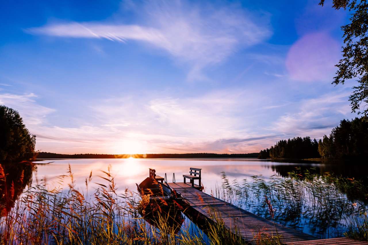 Jetée en bois avec bateau de pêche au coucher du soleil puzzle en ligne