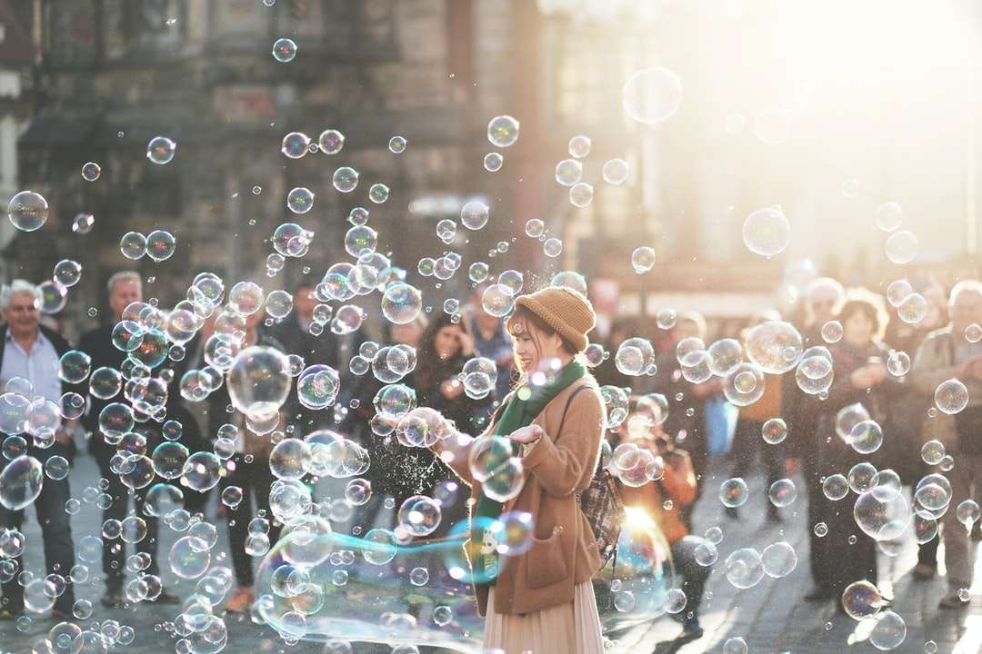 mujer de pie al aire libre rodeada de burbujas durante el día rompecabezas en línea
