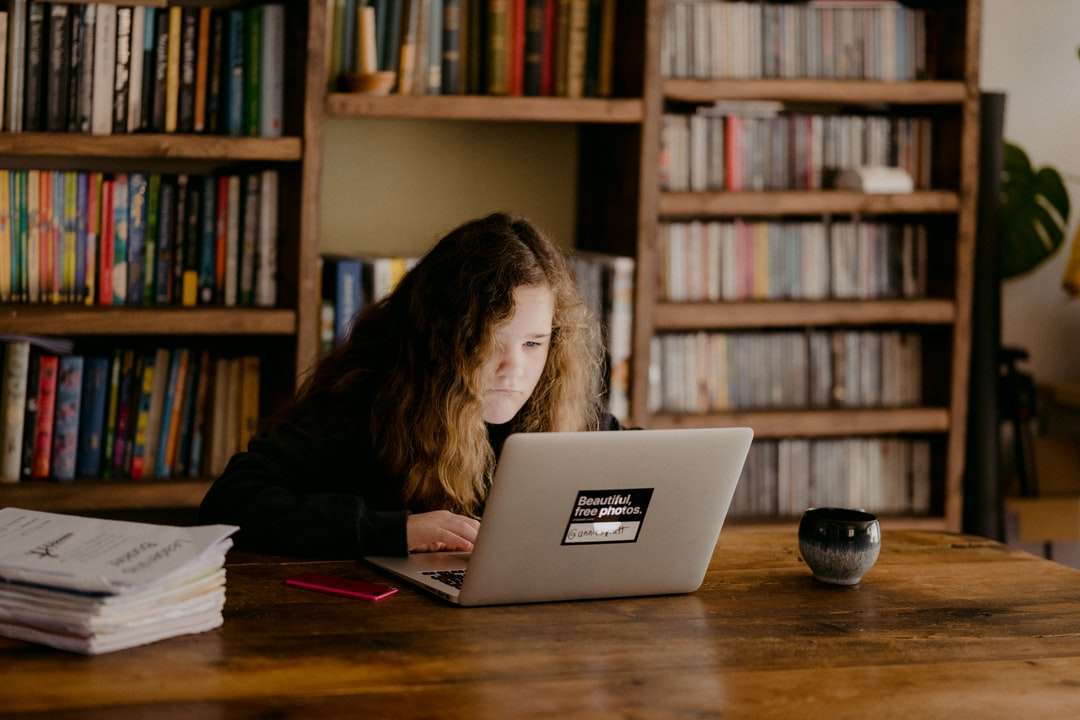žena v černé košili s dlouhým rukávem pomocí macbook air skládačky online