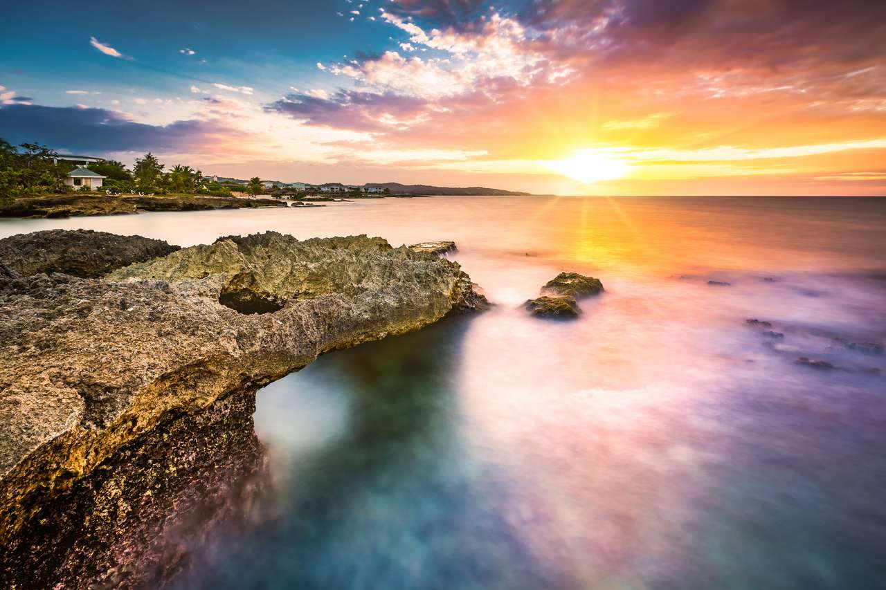 ηλιοβασίλεμα πάνω από μια βραχώδη παραλία στην Τζαμάικα online παζλ