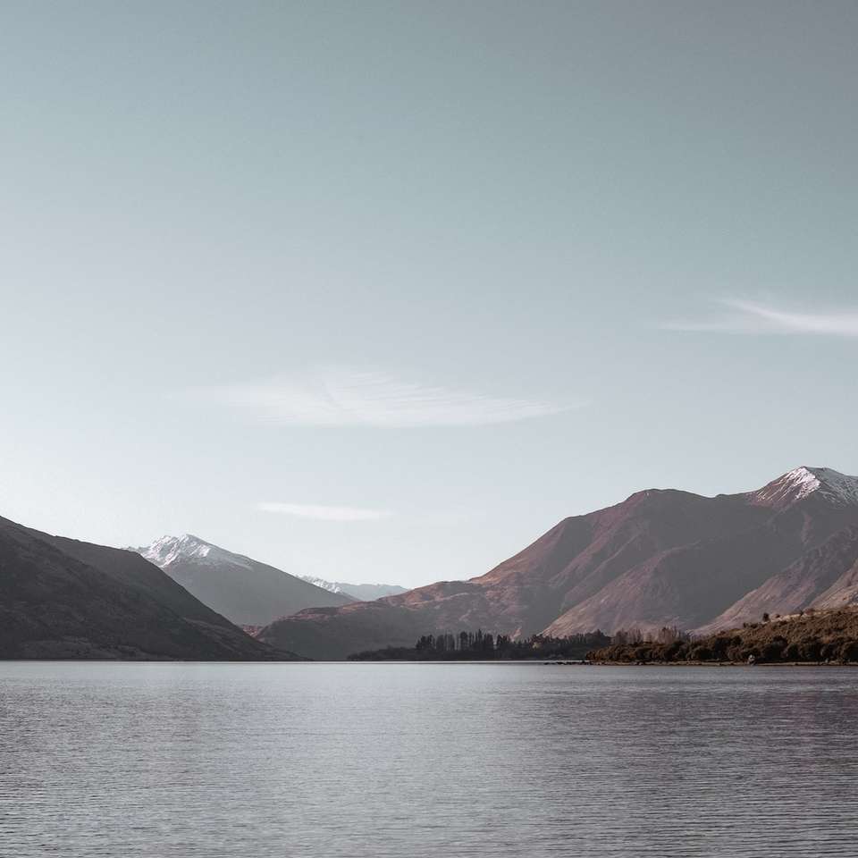 fotografía de paisaje de cuerpo de agua con montañas rompecabezas en línea