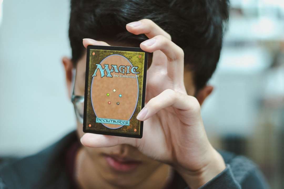 menino segurando o cartão comercial Magic: The Gathering quebra-cabeças online