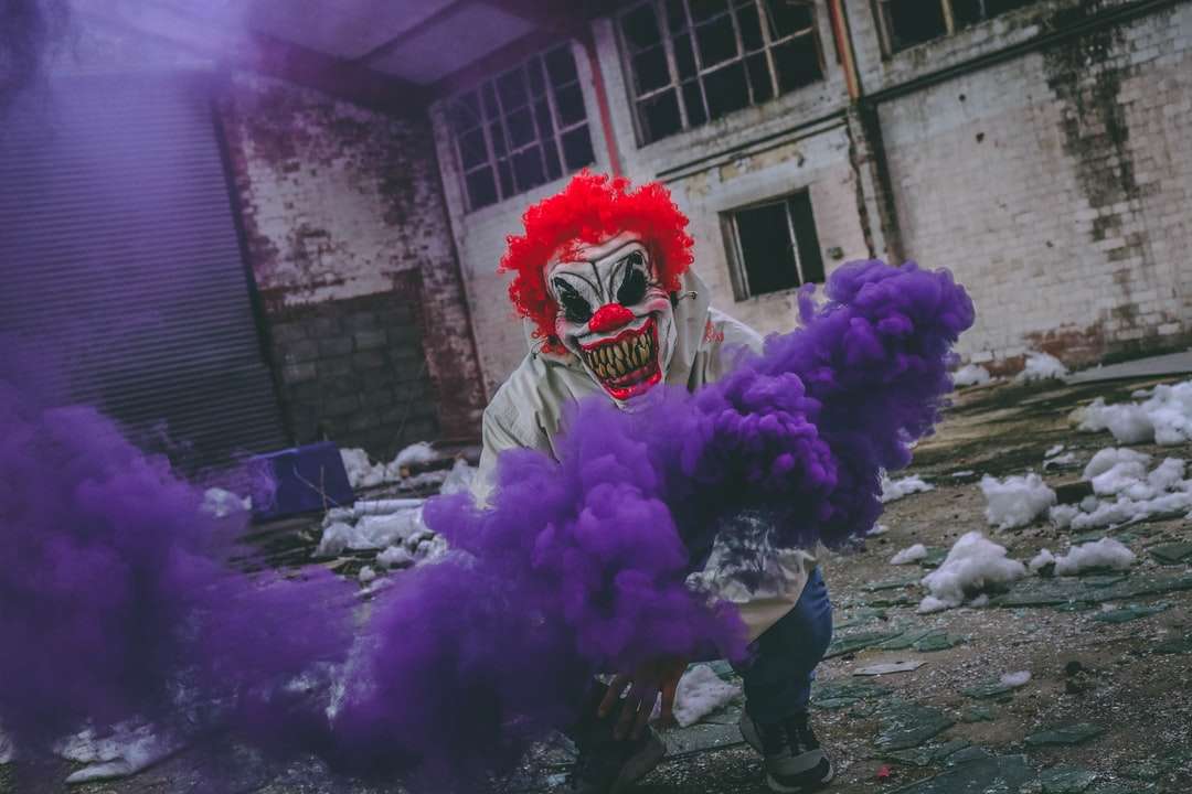 klaun drží fialovou kouřovou bombu v zničené budově online puzzle