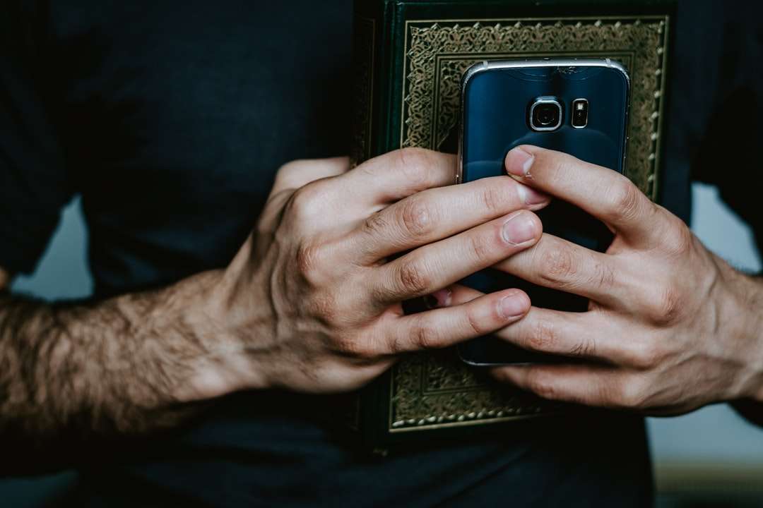 osoba držící černý a šedý smartphone online puzzle