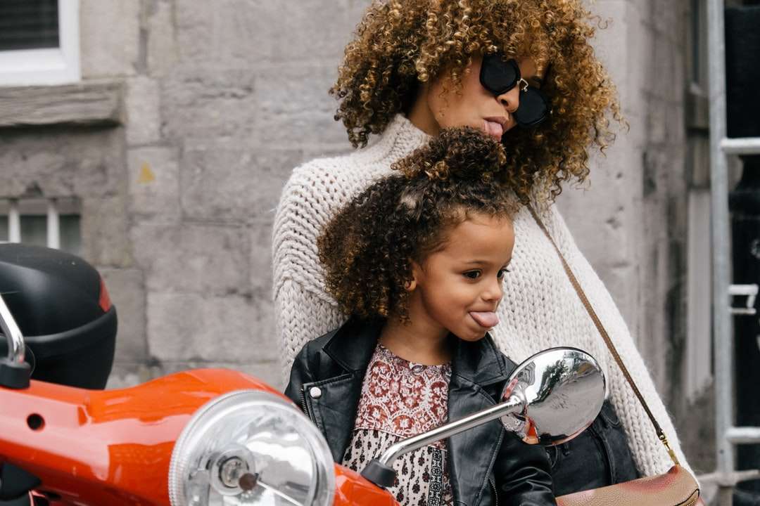 vrouw en meisje tonen hun tong naast motorfiets legpuzzel online