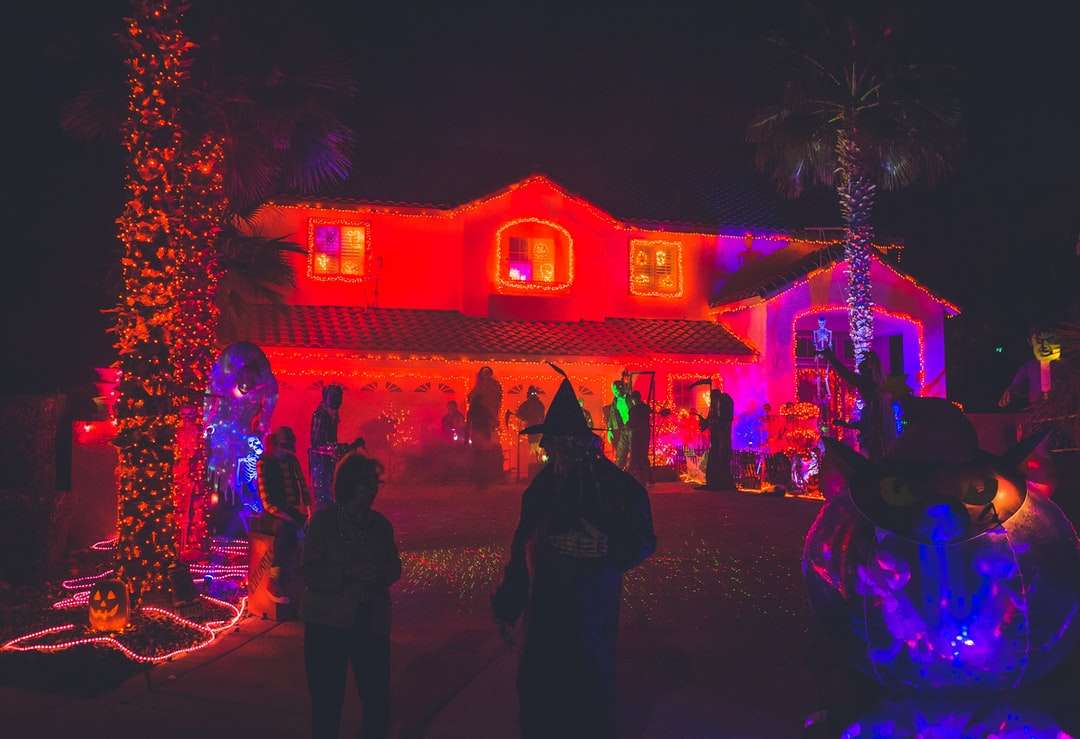 люди стоят возле дома с декором красного света онлайн-пазл